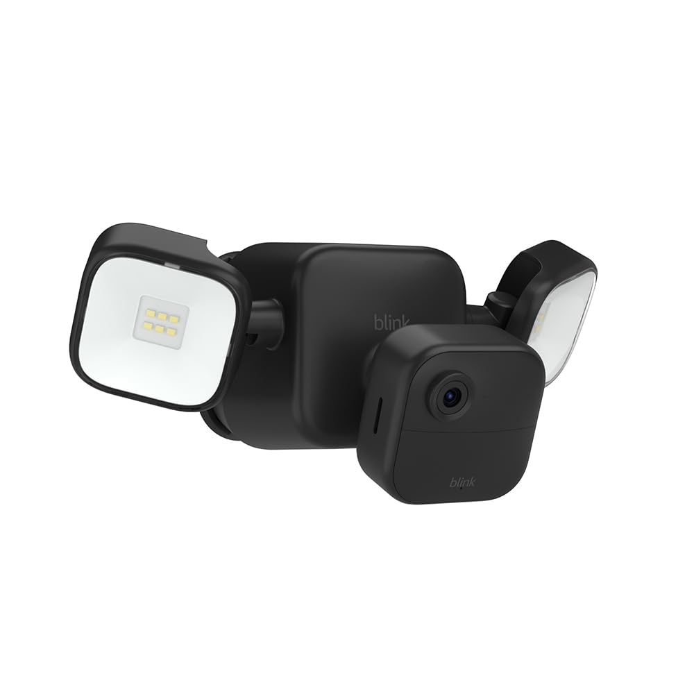 Caméra extérieure noire avec projecteur LED fixée sur une façade en pierre claire
