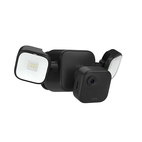Caméra extérieure noire avec projecteur LED fixée sur une façade en pierre claire