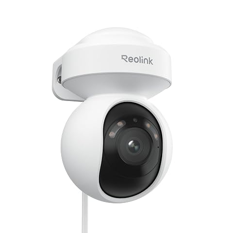 Caméra PTZ Reolink blanche fixée sur une façade grise et orientée vers un jardin extérieur.